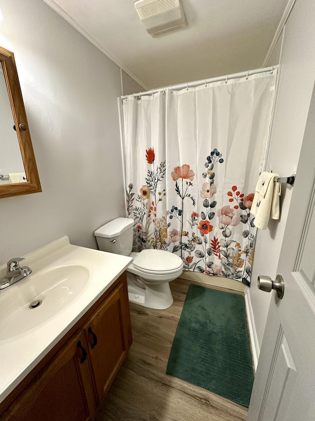 bathroom with visible vents, toilet, shower / tub combo, wood finished floors, and vanity