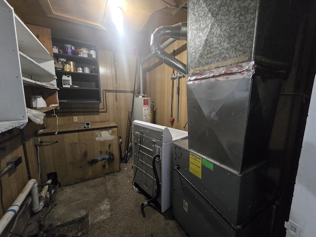 utility room with water heater, heating unit, and washer / clothes dryer