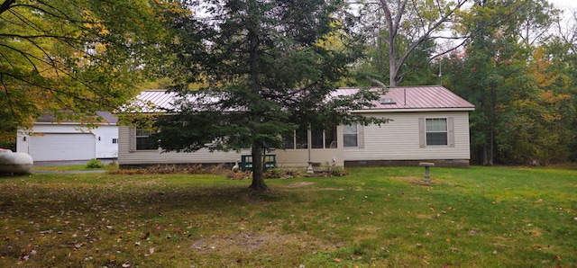 single story home featuring crawl space, a garage, metal roof, and a front yard