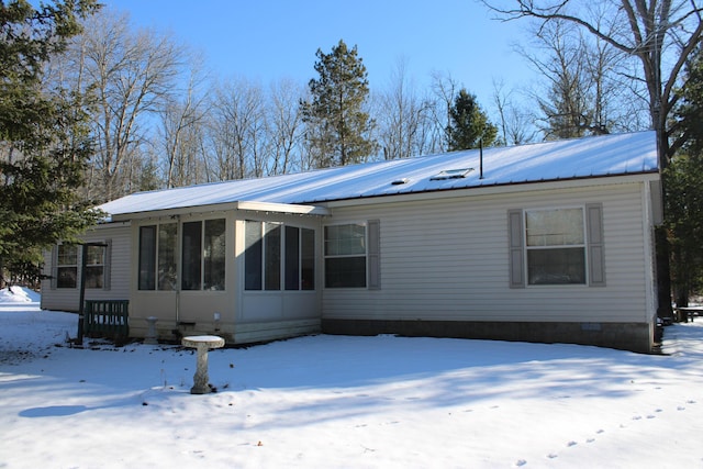 exterior space with metal roof, a sunroom, and crawl space