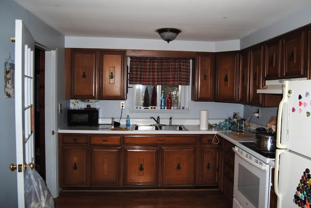 kitchen with a sink, white appliances, under cabinet range hood, and light countertops