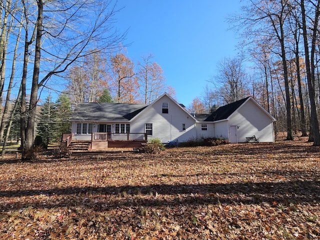 rear view of property featuring a wooden deck