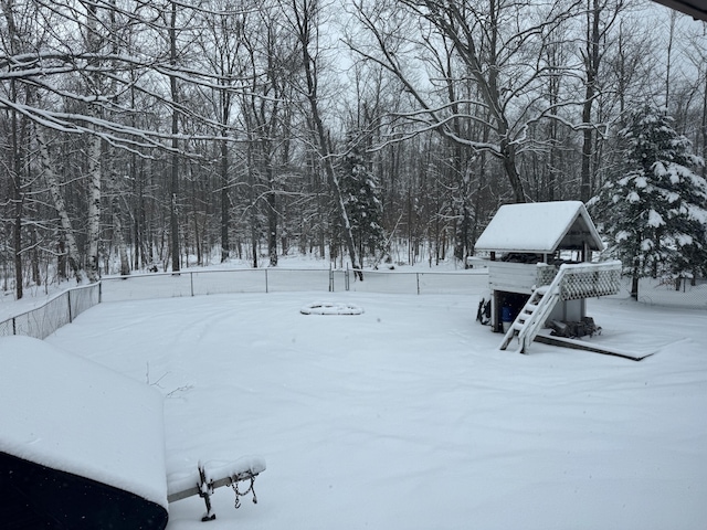 yard layered in snow with a fenced backyard