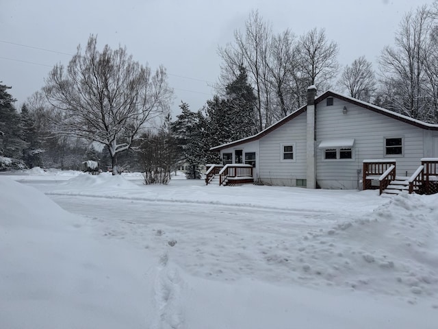 view of snow covered exterior with a wooden deck
