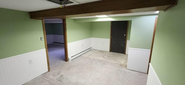 finished basement with wainscoting and a baseboard radiator