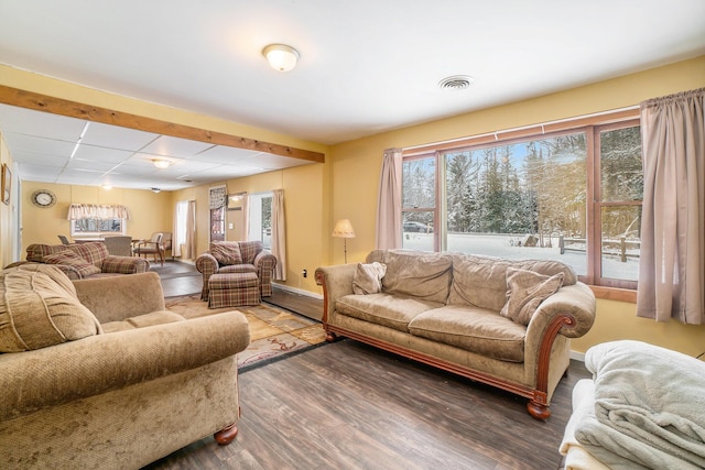 living area with wood finished floors, visible vents, and baseboards