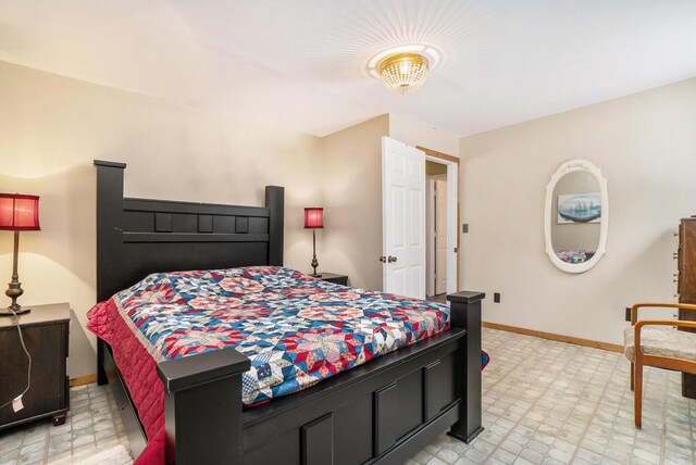 bedroom with light floors and baseboards