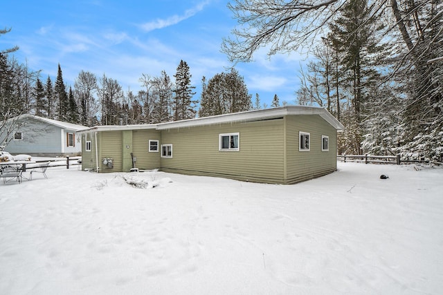 snow covered house with fence