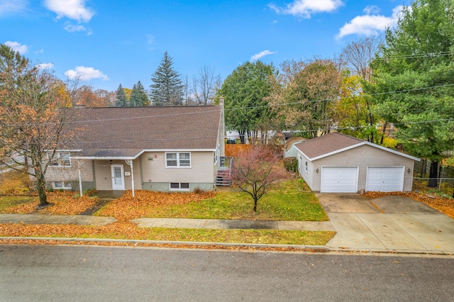 view of front of home with a front lawn, a detached garage, an outdoor structure, and roof with shingles