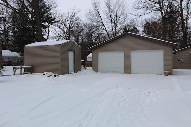 snow covered garage featuring a garage