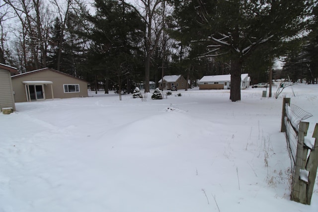 yard covered in snow featuring an outbuilding and a garage