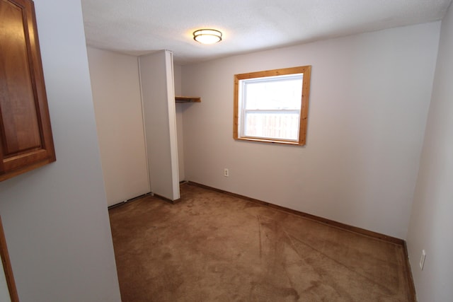 empty room featuring light colored carpet and baseboards