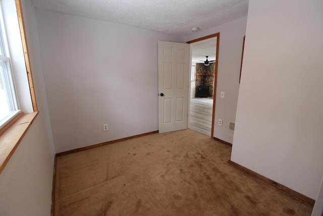 spare room featuring baseboards, carpet floors, and a textured ceiling