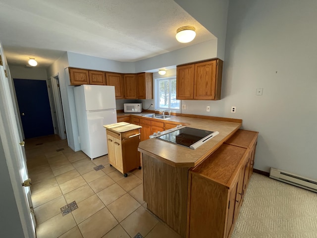 kitchen featuring white appliances, light tile patterned floors, a peninsula, a sink, and brown cabinets