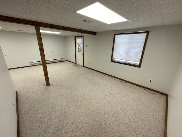 basement with light colored carpet, a paneled ceiling, baseboard heating, and baseboards