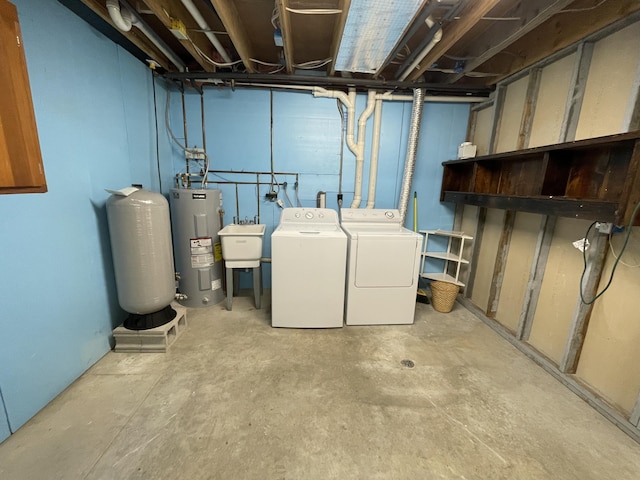 unfinished below grade area with a sink, electric water heater, and washing machine and dryer