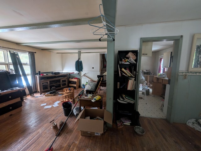 living area with beamed ceiling and wood finished floors