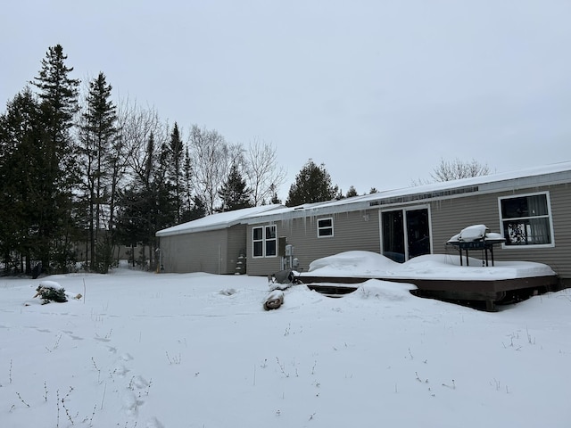 snow covered house featuring a garage