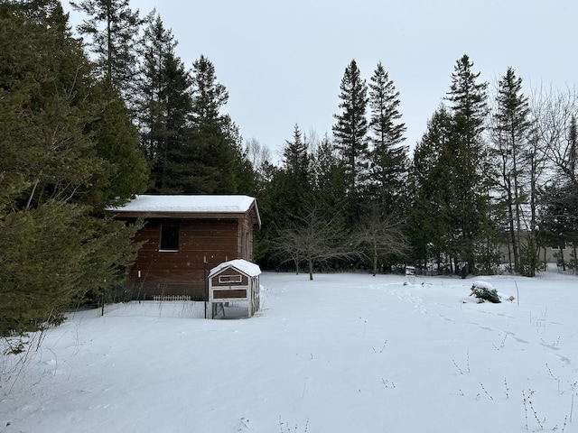 yard covered in snow featuring an outbuilding