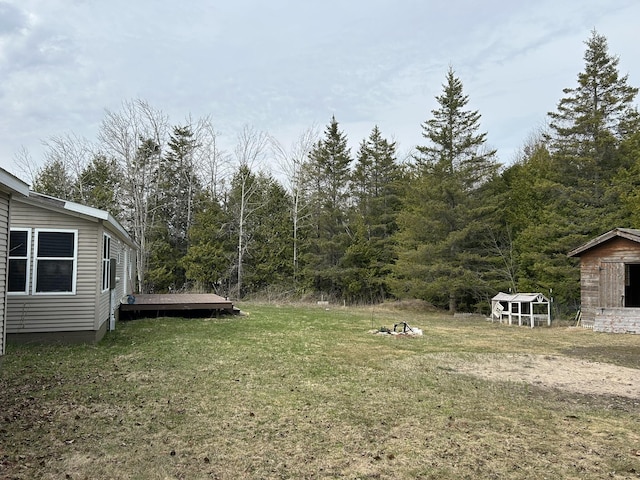 115 Sorrels Dr, Saint Ignace, MI 49781 - view of yard featuring a storage unit, a wooden deck, and an outdoor structure