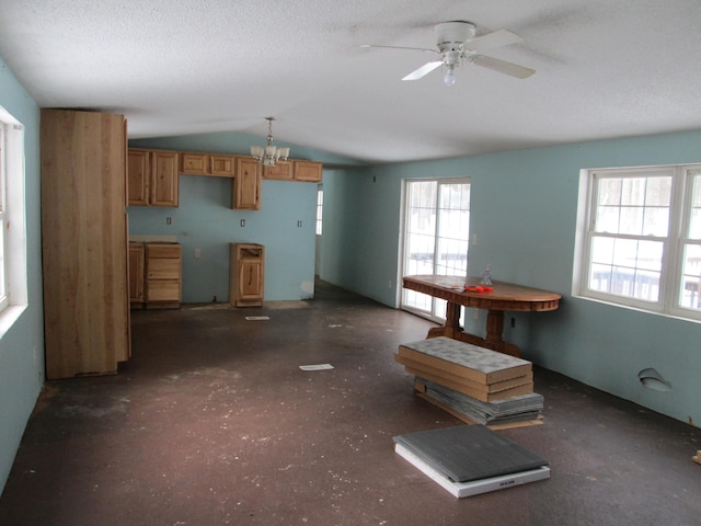 kitchen featuring brown cabinets, a textured ceiling, ceiling fan with notable chandelier, and vaulted ceiling