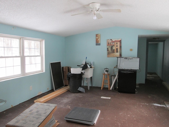 interior space with a textured ceiling, ceiling fan, and vaulted ceiling