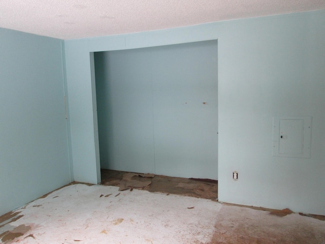 spare room featuring electric panel and a textured ceiling