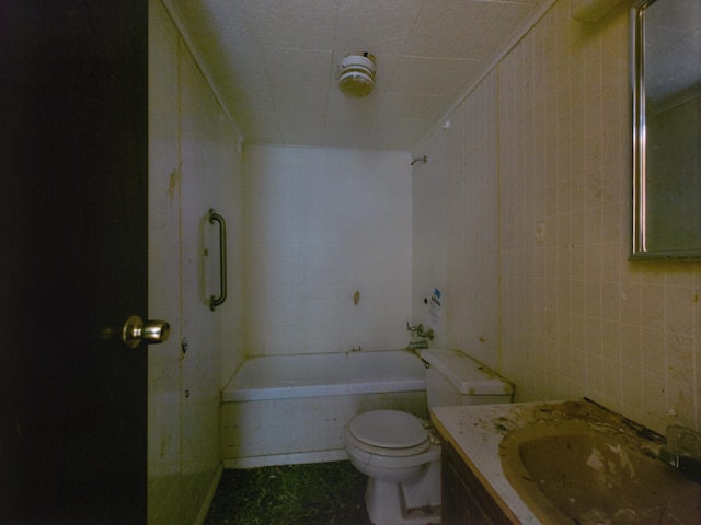 bathroom featuring vanity, toilet, tile walls, and tiled shower / bath combo