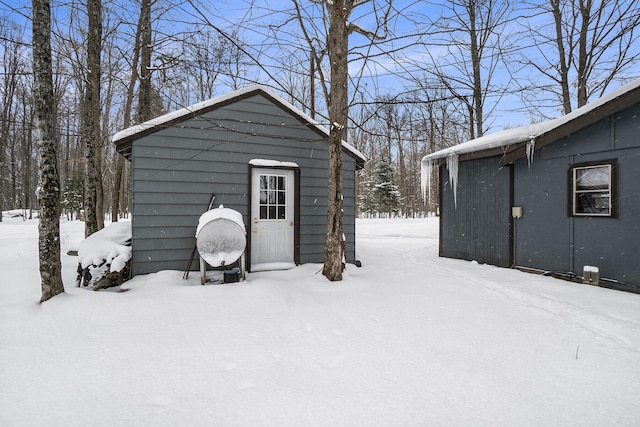 snow covered structure with an outbuilding