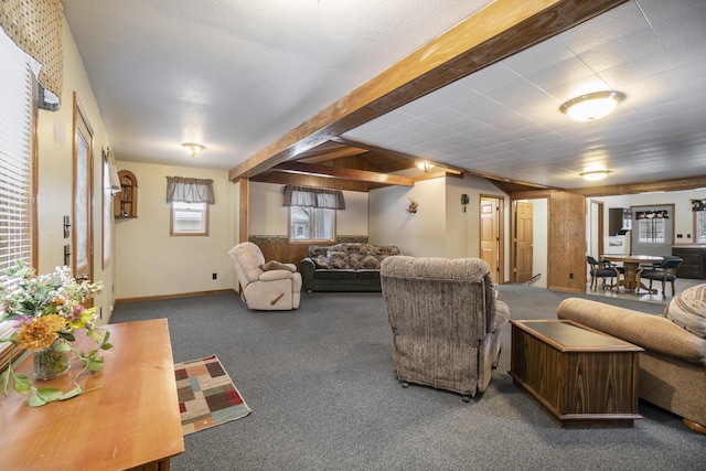 living area featuring beam ceiling, baseboards, and carpet floors