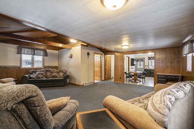 living room featuring visible vents, a wainscoted wall, carpet, wood walls, and lofted ceiling