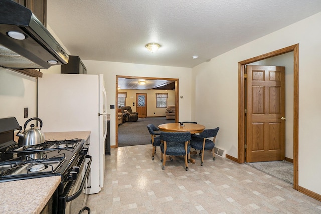 kitchen featuring range hood, baseboards, light countertops, black gas range, and a textured ceiling