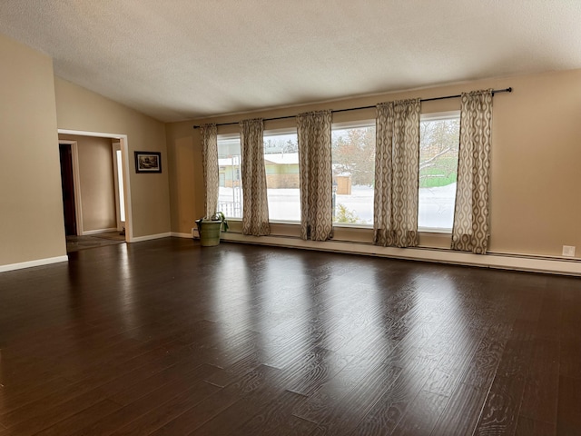 unfurnished room with wood finished floors, baseboards, vaulted ceiling, a textured ceiling, and a baseboard heating unit