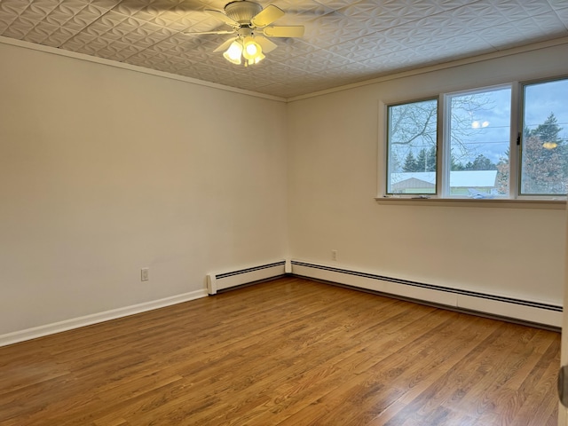 empty room with baseboards, ornamental molding, wood finished floors, an ornate ceiling, and a ceiling fan