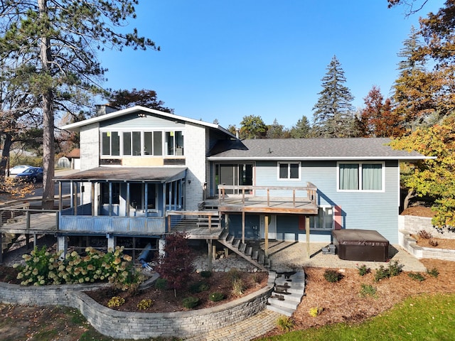 rear view of house with stairs, a wooden deck, a sunroom, and a chimney