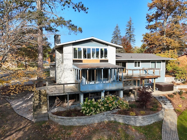 rear view of house with a wooden deck and a chimney