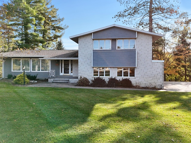 view of front facade featuring stone siding and a front yard