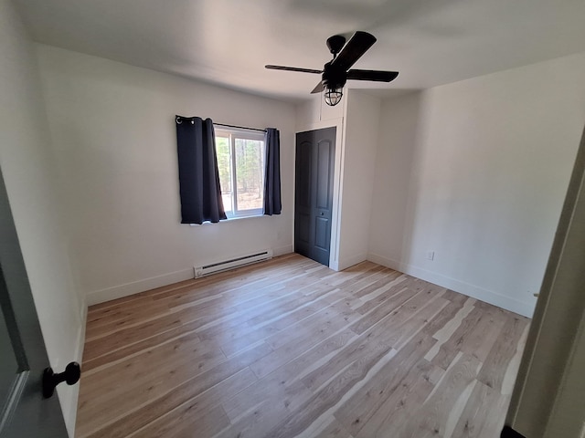 unfurnished bedroom with a baseboard radiator, light wood-style flooring, ceiling fan, and baseboards