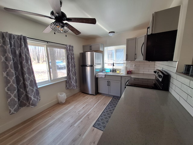 kitchen with stainless steel appliances, healthy amount of natural light, backsplash, and a ceiling fan