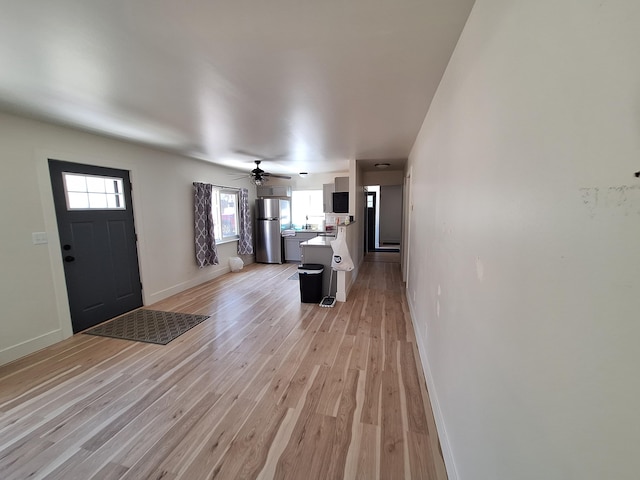 entryway featuring healthy amount of natural light, light wood finished floors, and baseboards