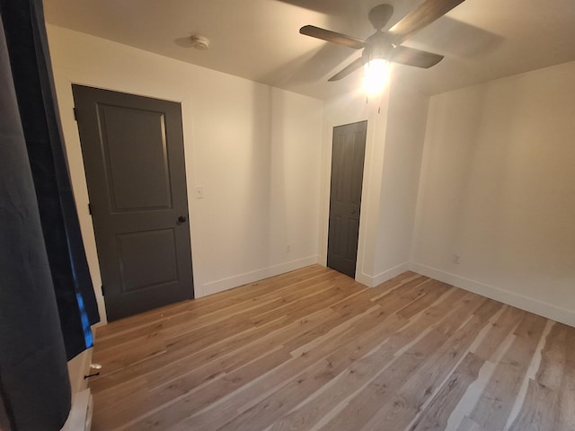 unfurnished bedroom with light wood-style floors, baseboards, and a ceiling fan