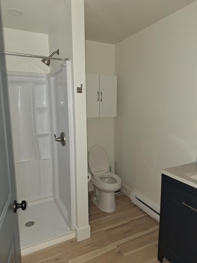 full bath featuring baseboard heating, wood finished floors, a shower stall, and toilet
