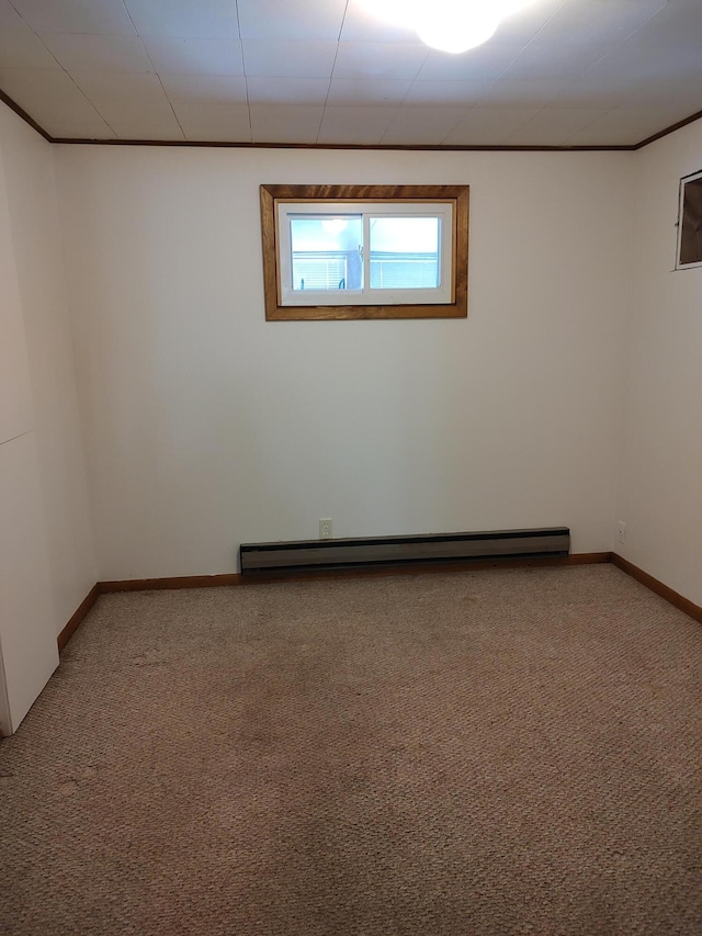 empty room with baseboard heating, crown molding, baseboards, and carpet floors