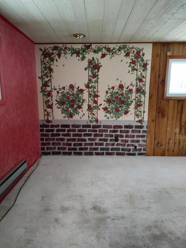 carpeted empty room with baseboard heating, wood ceiling, and brick wall