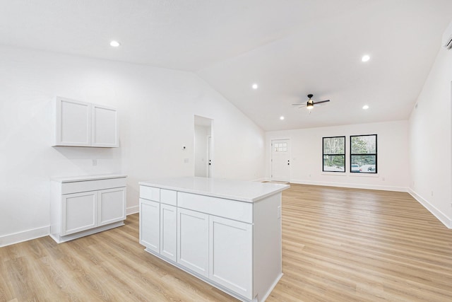 kitchen with light wood finished floors, ceiling fan, light countertops, and lofted ceiling