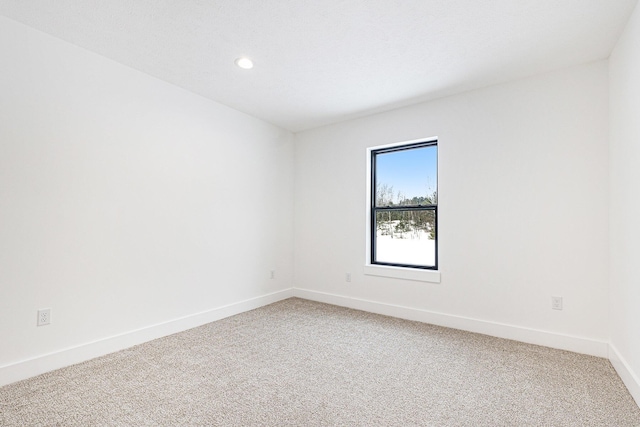 unfurnished room with recessed lighting, baseboards, and light colored carpet