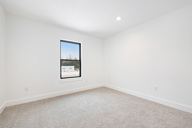 spare room featuring carpet flooring, recessed lighting, and baseboards