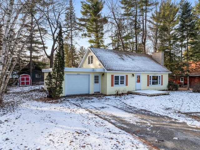 view of front of home with a shed, roof with shingles, a chimney, an outdoor structure, and an attached garage