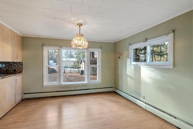 unfurnished dining area with light wood finished floors, baseboard heating, plenty of natural light, and ornamental molding