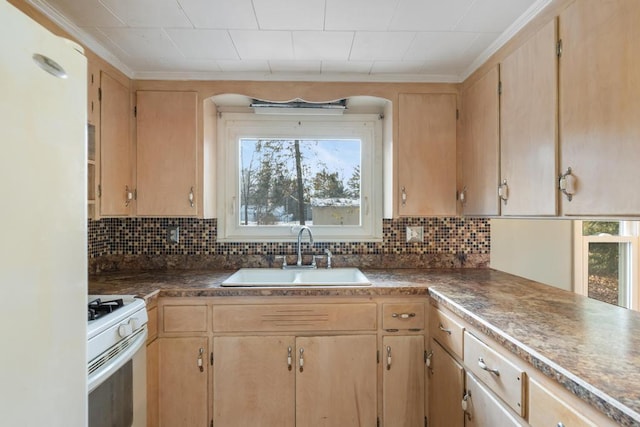 kitchen featuring dark countertops, backsplash, light brown cabinetry, white range with gas stovetop, and a sink